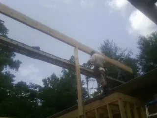 Carpenter setting a ridge beam over a new addition frame — Ice Dam Removal by Roofing Brothers in East Sandwich