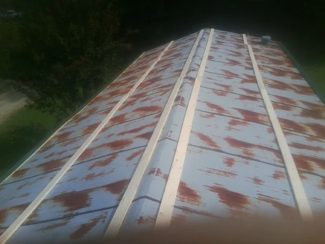 Rusted metal roof panels with new wood purlins before replacement — Storm Damage Roof Repair in East Sandwich by Roofing Brothers