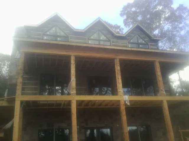Dormers and porch framing on a large log home under construction — Roof Coating work by our crew in East Sandwich