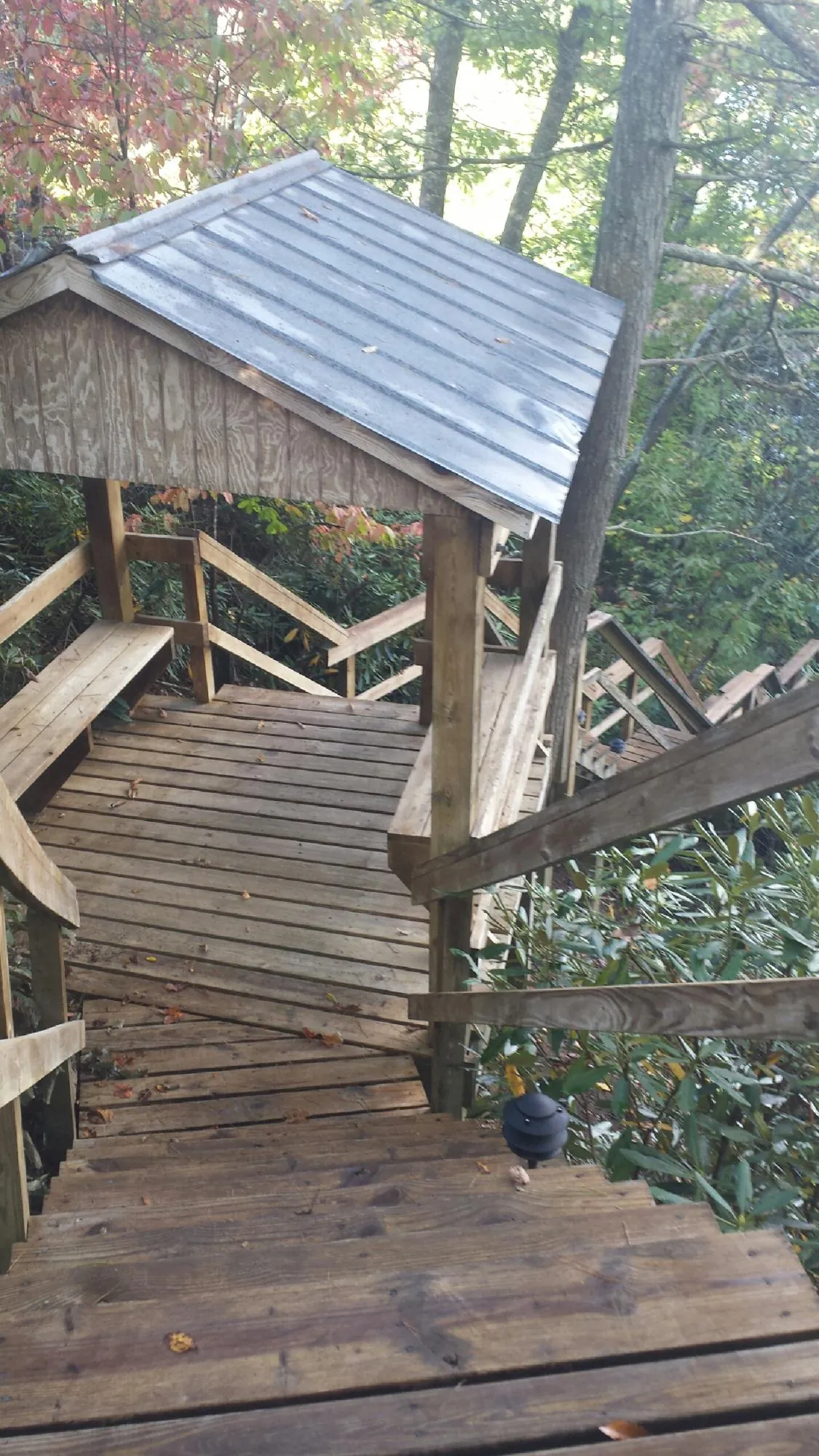 Metal roofed shelter over wooden steps on a wooded walkway — Skylight Repair & Installation work by our crew in East Sandwich