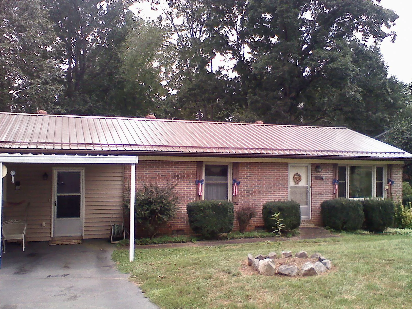 Bronze metal roof and carport on a brick ranch home — Roof Repair work by our crew in East Sandwich